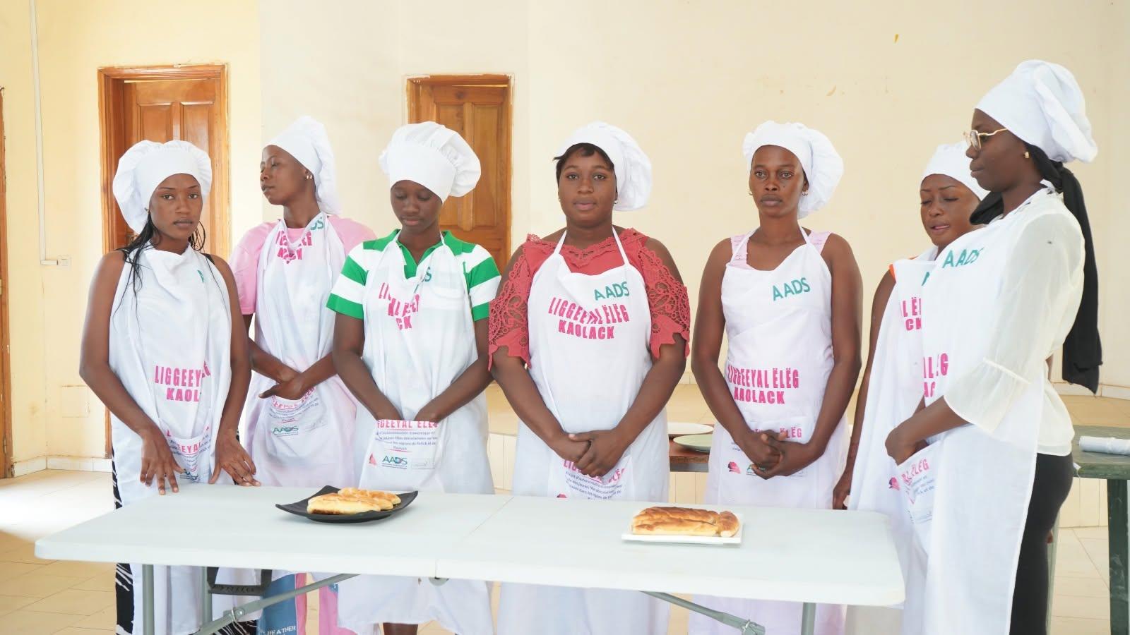 Participantes d'un GIE de Kaolack en tenue de formation lors d'une session de pâtisserie du projet LIGGEEYAL ËLËG, supervisée par l'AADS